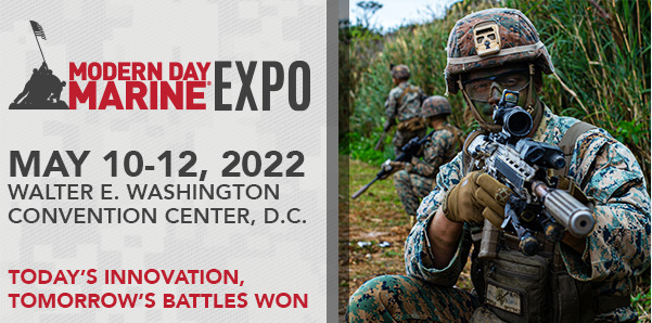 Title: Modern Day Marine Expo 2022

Alt-text: This is a promotional image for the Modern Day Marine Expo 2022. The image is split into two sections. On the left side, there’s a red background with white text that reads “Modern Day Marine Expo, May 10-12, 2022, Walter E. Washington Convention Center, D.C. Today’s innovation, tomorrow’s battles won.” On the right side, there’s a photo of a soldier in camouflage gear holding a rifle with a scope. The soldier is wearing a helmet with a black visor and is crouching in a field.